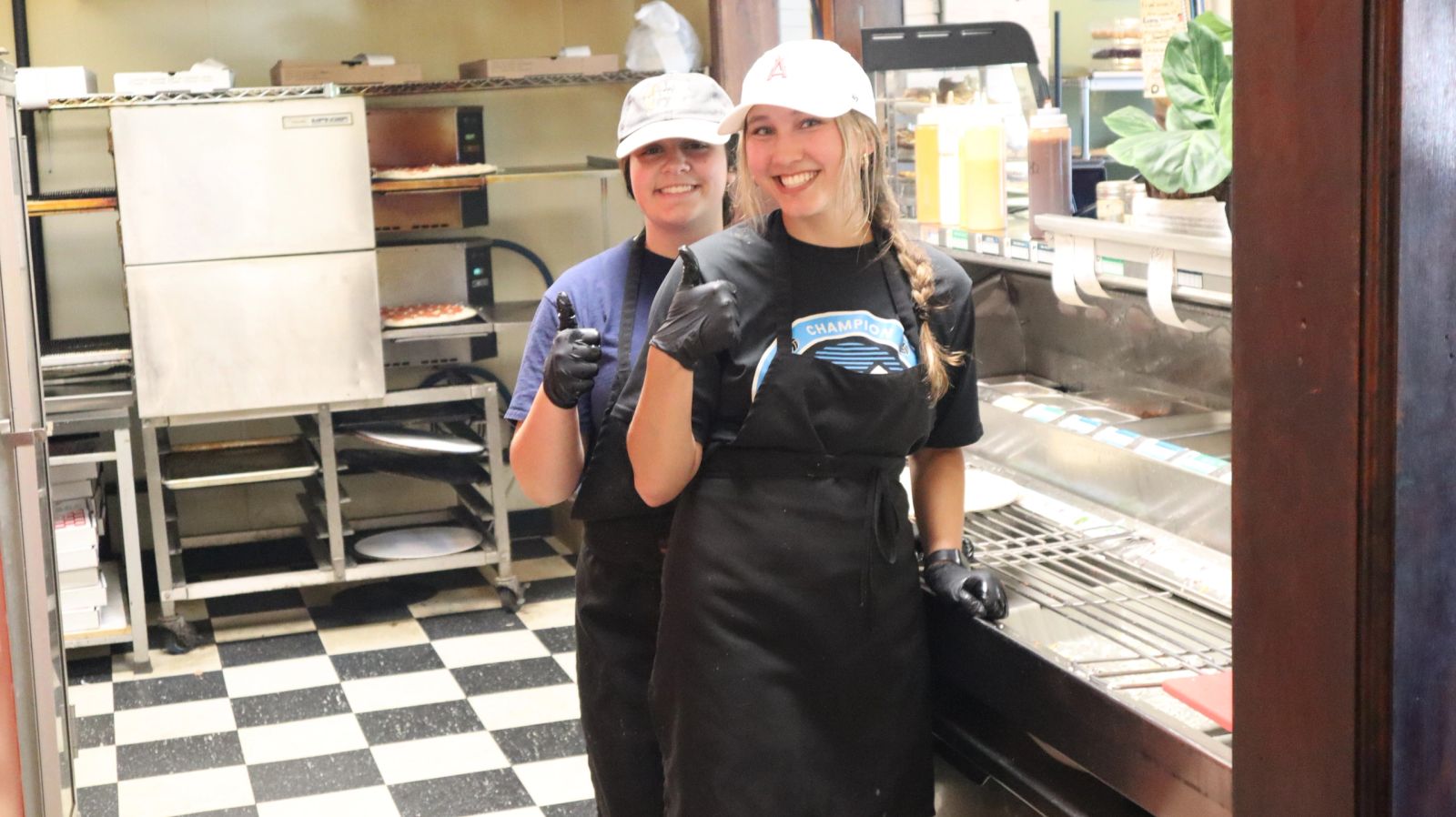 The Pizza Delizia family behind the counter, ready to serve